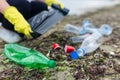 volunteer collecting plastic bottles on a polluted beach, highlighting ocean Royalty Free Stock Photo