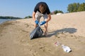 A volunteer collects plastic waste on the beach. Environmental problems, environmental pollution. River water pollution