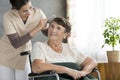 Volunteer combing older patient`s hair