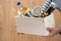 Volunteer with donation box with food stuffs on wooden background Royalty Free Stock Photo