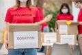 Volunteer girl holding donation box and friends behind