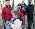 Volunteer girl releases a bat. A lot of people around her phytographs with smartphones and cameras