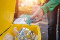 Volunteer girl sorts garbage in the street of the park. Concept of recycling.