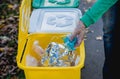 Volunteer girl sorts garbage in the street of the park. Concept of recycling.