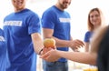 Volunteer giving apple to poor person