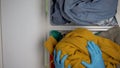 Volunteer hands dividing denim and textile clothing on waste sorting line, reuse