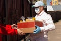 Volunteer hands over a box of food to those in need