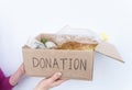 Volunteer holding food donation box. Support food banks concept. Funds and Donations. Charity donations. Isolated on white Royalty Free Stock Photo