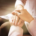 Volunteer holding hands with woman in sunlit room