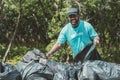 Volunteer man clean up garbage waste in the forest for ecology in Earth day