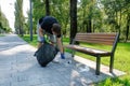 A volunteer man picks up trash in the park on a sunny warm day. Cleanliness of the environment. Environmental problems. Royalty Free Stock Photo