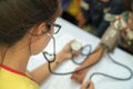 Volunteer nurse measuring blood pressure of poor Asian people outdoors closeup