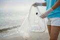 Volunteer pick up trash garbage at the beach and plastic bottles are difficult decompose prevent harm aquatic life. Earth,