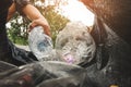 The volunteer picking up a bottle plastic in to a bin bag for cleaning, volunteering concept.