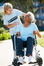 Volunteer Pushing Senior Woman In Wheelchair Royalty Free Stock Photo