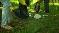 Volunteer scavenge plastic garbage in the summer park. Ecology concept