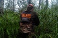 Volunteer from the search and rescue squad LIZA ALERT in search of a missing person in the forest, the inscription in Russian