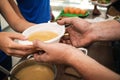 Volunteer serving food to poor people in charity centre Royalty Free Stock Photo