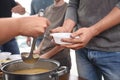 Volunteer serving food to poor people in charity centre Royalty Free Stock Photo