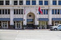 The Volunteer State Life Building with an American flag and Tennessee State flag flying surrounded by buildings in downtown