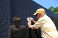 Volunteer take a rubbing of a Name at the Vietnam War Memorial on the Mall in Washington DC. USA