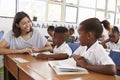 Volunteer teacher helping school kids in classroom, close up Royalty Free Stock Photo