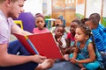 Volunteer teacher reading to a class of preschool kids Royalty Free Stock Photo