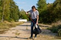 Volunteer woman picking up plastic litter in forest. Cleaning environment concept