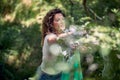 Volunteer woman picking up trash in nature. Cleaning up forest or park doing charity work. Environmentalism, green, lifestyle