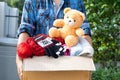 Volunteer woman provide clothing donation box with used clothes and doll to support help for refugee, homeless or poor people in