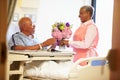 Volunteer Worker Tidying Male Patient's Hospital Room