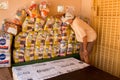 A volunteer working wearing a protective mask as he counts bags of food to be given away to the poor