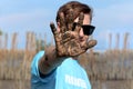 Volunteer young man in blue t-shirt showing hand covered mud dirty after planting sapling tree in deep mud at mangrove forest for Royalty Free Stock Photo