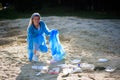 volunteering, charity, cleaning, people and ecology concept, volunteer with garbage bag cleaning area on the beach Royalty Free Stock Photo