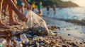 Volunteers cleaning up the beach, collecting plastic and glass bottles in a big plastic bag. Royalty Free Stock Photo