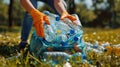 Volunteers cleaning up the park, collecting bottles in a big plastic bag. Royalty Free Stock Photo