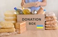 Volunteers collecting food into donation box for the people of Ukraine. Pasta, oil, canned food, condensed milk, cookies, sugar, Royalty Free Stock Photo