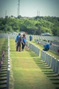 Volunteers and family members place flags on fallen heroes heads