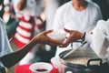 Volunteers giving food to poor people: The concept of food sharing Help solve Hunger for the homeless Royalty Free Stock Photo