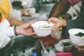 Volunteers giving food to poor people: The concept of food sharing Help solve Hunger for the homeless Royalty Free Stock Photo