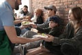 Volunteers giving food to poor people Royalty Free Stock Photo