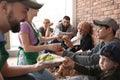 Volunteers giving food to poor people