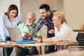 Volunteers help senior people on the computer. Young people giving senior people introduction to internet