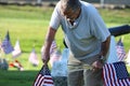 Volunteers placing an American Flag on the grave of a Military Veteran for Memorial Day