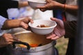 Volunteers provide food for beggars : Concepts Feeding and help : The hands of the rich give food to the hands of the poor