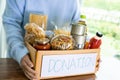 Volunteers putting various dry food in donation box for help people Royalty Free Stock Photo