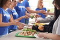 Volunteers serving food to poor people Royalty Free Stock Photo