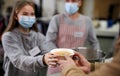 Volunteers serving hot soup for homeless in community charity donation center, coronavirus concept.