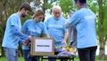 Volunteers sorting clothes putting in donation box, philanthropic organization