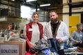 Volunteers sorting out donated clothes in community charity donation center. Royalty Free Stock Photo